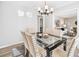 Dining room with modern light fixture, neutral colors, and a view into the living room at 3448 Montreal Way, Tucker, GA 30084