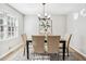 Elegant dining area featuring a modern chandelier, table setting, and large window with natural light at 3448 Montreal Way, Tucker, GA 30084
