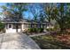 View of the home showcasing the driveway, a screened-in carport, and mature trees surrounding the property at 3448 Montreal Way, Tucker, GA 30084