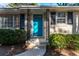 Home's inviting front entrance with blue door, black shutters, and wrought iron porch supports at 3448 Montreal Way, Tucker, GA 30084