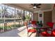 Relax on the screened patio with ceiling fan and backyard views from the charming red chairs at 3448 Montreal Way, Tucker, GA 30084