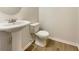 Clean powder room with pedestal sink and wood-look flooring at 4444 Spring Mtn Ln, Powder Springs, GA 30127