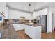 Spacious kitchen featuring granite countertops, stainless steel appliances, and white cabinetry at 627 Village Manor Pl, Suwanee, GA 30024