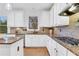 Modern kitchen with granite countertops, stainless steel appliances, and white cabinets at 627 Village Manor Pl, Suwanee, GA 30024