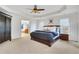 Large main bedroom with plush carpeting, ceiling fan and ensuite bathroom at 627 Village Manor Pl, Suwanee, GA 30024