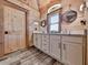 Bathroom vanity featuring double sinks, white cabinetry, wood paneled walls and floors, and stylish, round, mirror accents at 255 Marks Way, Canton, GA 30115
