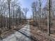 Long gravel driveway leading to a secluded home amidst lush trees at 255 Marks Way, Canton, GA 30115