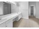Bathroom featuring double sinks, white cabinetry, tiled floors, and shower-tub combination at 2756 Palmview Sw Ct, Atlanta, GA 30331