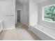 Bright bathroom featuring a soaking tub, large window, and tiled flooring at 2756 Palmview Sw Ct, Atlanta, GA 30331
