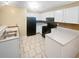 Kitchen with white cabinets, black appliances, and tile floors at 1089 Brittwood Pl, Norcross, GA 30093