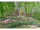 Spacious wooded backyard with the home in the background and a view of the back deck on the right at 4259 Arbor Club Dr, Marietta, GA 30066