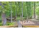 Lush backyard featuring a stone pathway leading to a charming deck surrounded by tall trees at 4259 Arbor Club Dr, Marietta, GA 30066