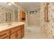 This bathroom features patterned wallpaper, a vanity, and a shower-tub combination at 4259 Arbor Club Dr, Marietta, GA 30066