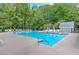 Full view of the community pool with clear water, lounge chairs, umbrellas and trees all around at 4259 Arbor Club Dr, Marietta, GA 30066