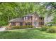 Charming brick two-story home boasts a well-manicured lawn, verdant landscaping, and a serene wooded backdrop at 4259 Arbor Club Dr, Marietta, GA 30066