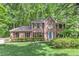 Charming brick two-story home features a manicured lawn, verdant landscaping, and a serene wooded backdrop at 4259 Arbor Club Dr, Marietta, GA 30066