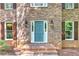 Charming brick home entry featuring a turquoise front door, black sconces, brick steps and well-maintained shutters at 4259 Arbor Club Dr, Marietta, GA 30066