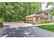 Attached two-car garage alongside a charming brick two-story home, verdant landscaping, and an extended driveway at 4259 Arbor Club Dr, Marietta, GA 30066