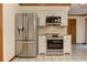 Kitchen with stainless steel refrigerator, oven, and microwave with white cabinets and tile floors at 4259 Arbor Club Dr, Marietta, GA 30066