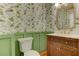 Charming powder room featuring a wood vanity, white countertops, and delightful floral wallpaper at 4259 Arbor Club Dr, Marietta, GA 30066