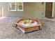 Sandbox in the backyard with toys and gravel all around, a great space for children to play in at 4259 Arbor Club Dr, Marietta, GA 30066