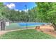 Exterior view of the community tennis court with benches, lush greenery and a net at 4259 Arbor Club Dr, Marietta, GA 30066