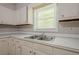 Traditional kitchen featuring white cabinets, laminate countertop, and double stainless steel sink beneath a window at 3710 Lynn Dr # A & B, Powder Springs, GA 30127