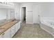 Elegant bathroom with double vanity, granite countertop, and a large soaking tub at 7085 Magnolia Ln, Fairburn, GA 30213