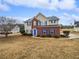Two-story house with brick and siding, blue shutters, and a landscaped lawn at 7085 Magnolia Ln, Fairburn, GA 30213