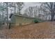 View of home's backyard with leaves on the ground and view of side of home at 180 Sears Cir, Covington, GA 30016
