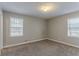 Bright bedroom featuring neutral walls, carpet, and a pair of large windows to let in natural light at 180 Sears Cir, Covington, GA 30016