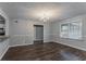 Bright dining room featuring modern chandelier, wood floors, and views to kitchen and living spaces at 180 Sears Cir, Covington, GA 30016