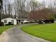 White ranch house with circular driveway and mature trees at 75 Azalea Trl, Carrollton, GA 30116