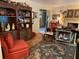 Living area with red armchair, patterned rug, and built-in shelving at 75 Azalea Trl, Carrollton, GA 30116