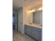 Double vanity bathroom with gray cabinets and a large mirror at 1455 Weeping Tree Cir, Auburn, GA 30011