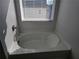 Bathroom with a large garden tub and window with blinds at 1455 Weeping Tree Cir, Auburn, GA 30011