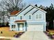 Charming two-story home featuring light blue siding, red roof, white trim, and an attached two-car garage at 4405 Belcamp Rd, Fairburn, GA 30213