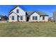 Two-story house with white brick and gray roof, nicely landscaped lawn at 8 Longhorn Way, Auburn, GA 30011