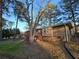 Back view of brick ranch house with deck and large tree in the yard at 5737 Lorraine Dr, Stone Mountain, GA 30087