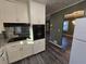 Bright kitchen features white cabinets, black appliances, and gray flooring at 5737 Lorraine Dr, Stone Mountain, GA 30087