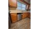 Modern kitchen with wood cabinets, stainless steel dishwasher, tile backsplash, and wood-look flooring at 125 Odyssey Turn, Conyers, GA 30012
