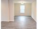 A sunny living room showcasing newly installed grey flooring, neutral walls and modern light fixture at 1421 Eason St, Atlanta, GA 30314