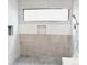 Modern walk-in shower featuring neutral tile, rock flooring, and sleek fixtures at 1421 Eason St, Atlanta, GA 30314