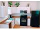 Updated kitchen with white cabinets, stainless steel appliances, a modern sink and decorative greenery on top of cabinets at 94 Moury Se Ave, Atlanta, GA 30315