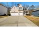 Inviting two-story home boasts a long driveway and two-car garage, set against a backdrop of trees and clear skies at 2536 Dayview Ln, Atlanta, GA 30331