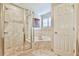 This bathroom features a tiled shower and bath with glass doors, plus a bright window for natural light at 2548 Brentmoor Ct, Suwanee, GA 30024