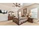 This bedroom has a ceiling fan, multiple windows with blinds, a bed, and a dresser with lamps at 2548 Brentmoor Ct, Suwanee, GA 30024