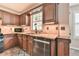 Beautiful kitchen with wood cabinetry, tile backsplash and stainless steel dishwasher at 2548 Brentmoor Ct, Suwanee, GA 30024