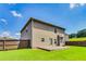 Home exterior view shows yard with wooden deck, lush grass, and wood fencing at 8051 Nolan Trl, Snellville, GA 30039