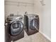 Modern laundry room with front-loading washer and dryer and storage shelf at 8051 Nolan Trl, Snellville, GA 30039